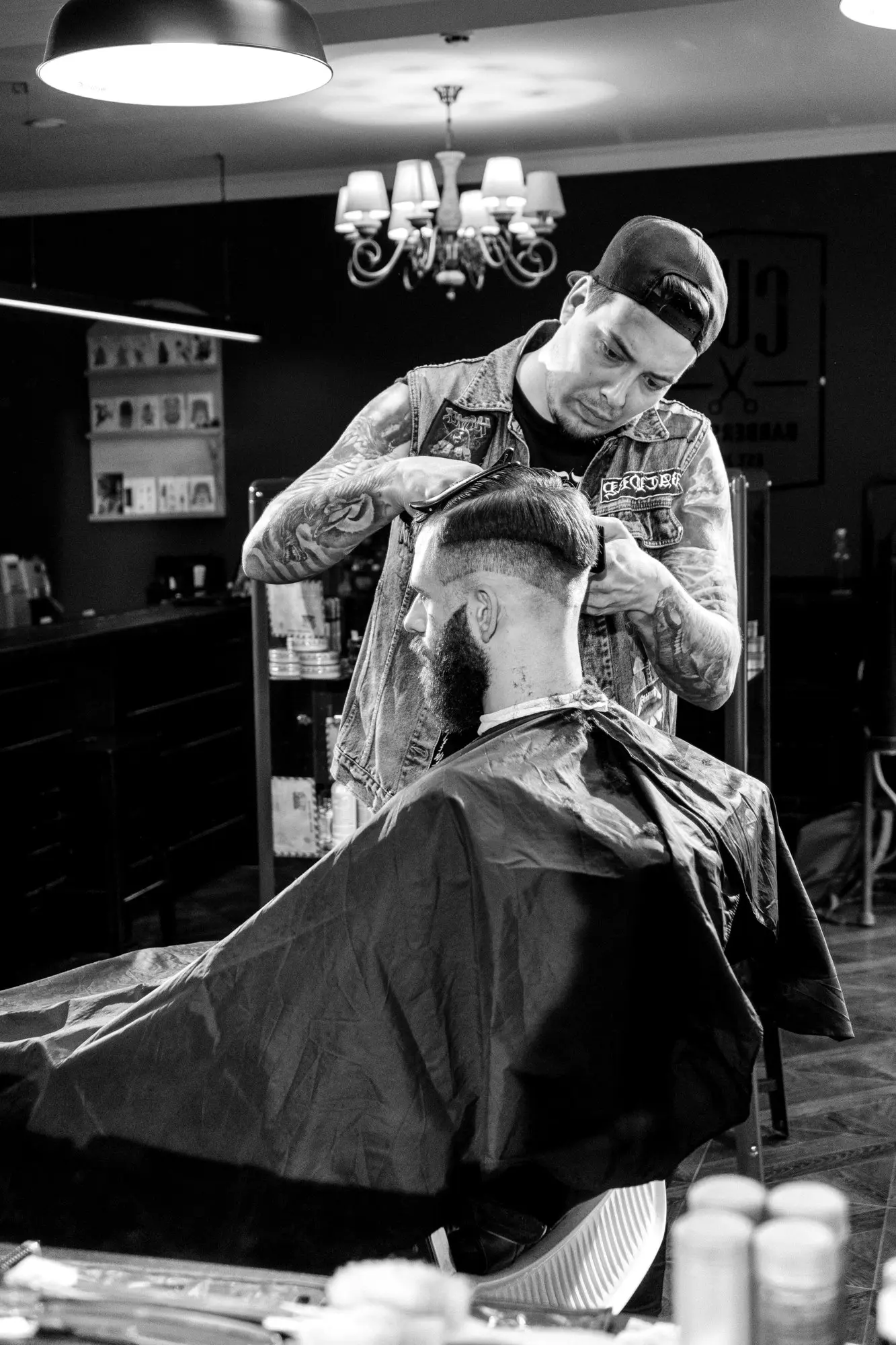 Barbero cortando el cabello a un cliente en la estación de trabajo