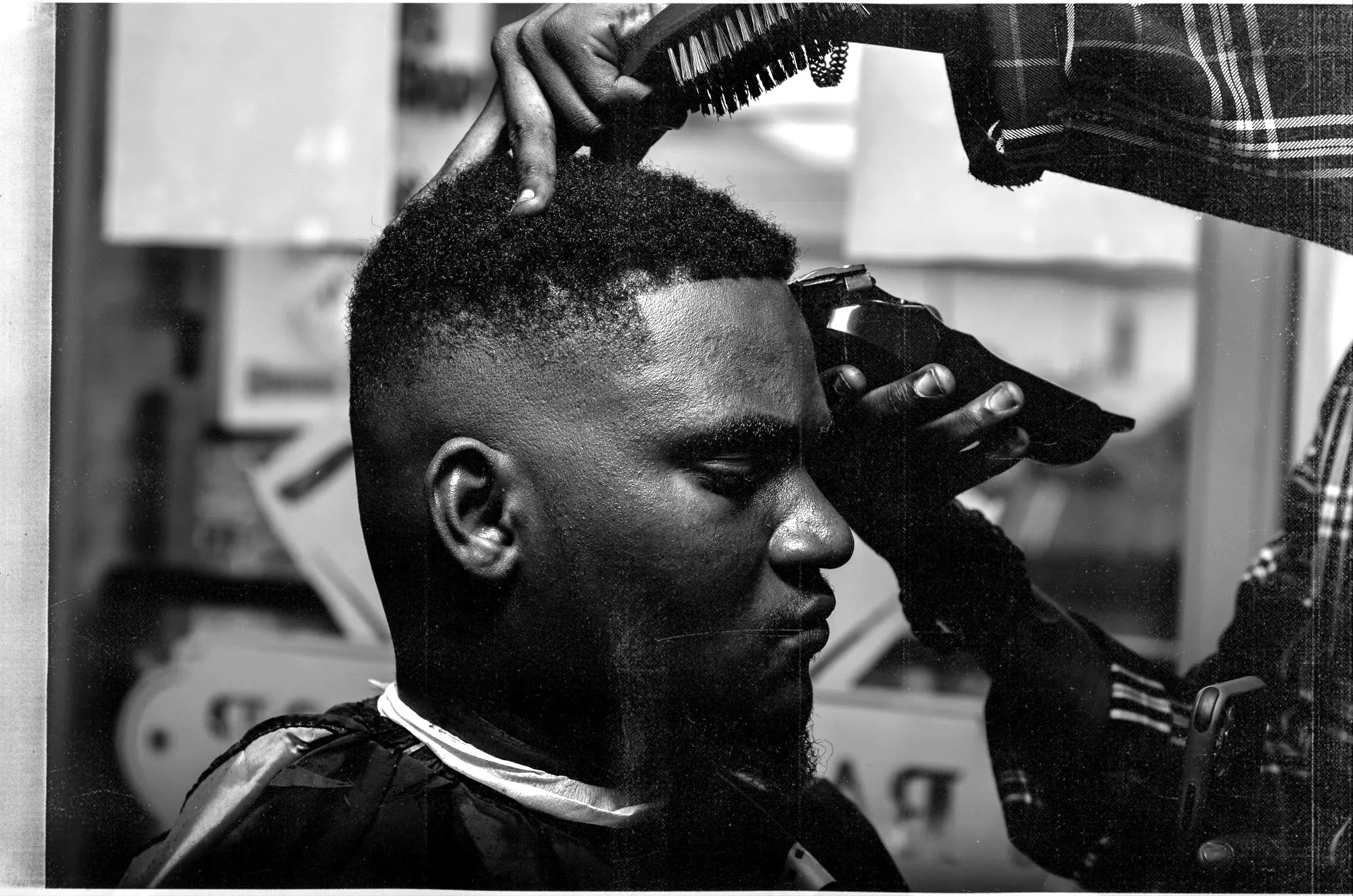 Barbero haciendo un degradado con máquina a un cliente